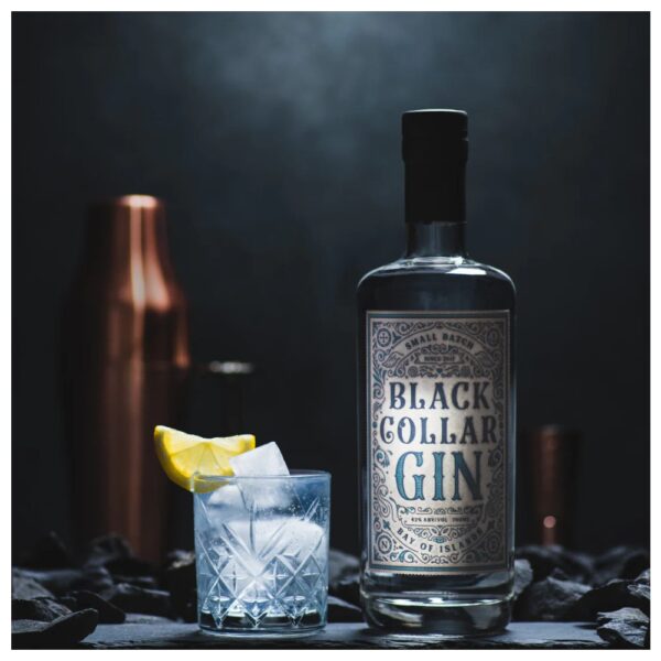 Bottle of Black Collar Gin next to a glass filled with ice and a lemon slice.