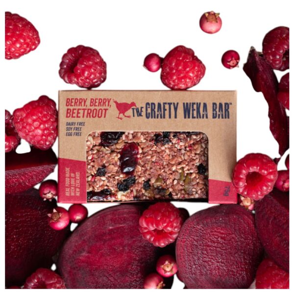 Crafty Weka Berry Berry Beetroot Bar packaging surrounded by raspberries and beetroot.