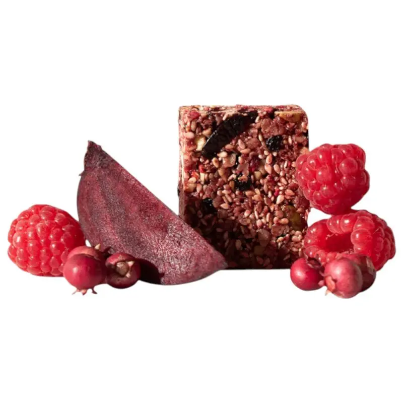 Berry beetroot bite snack bar surrounded by raspberries and a slice of beetroot.