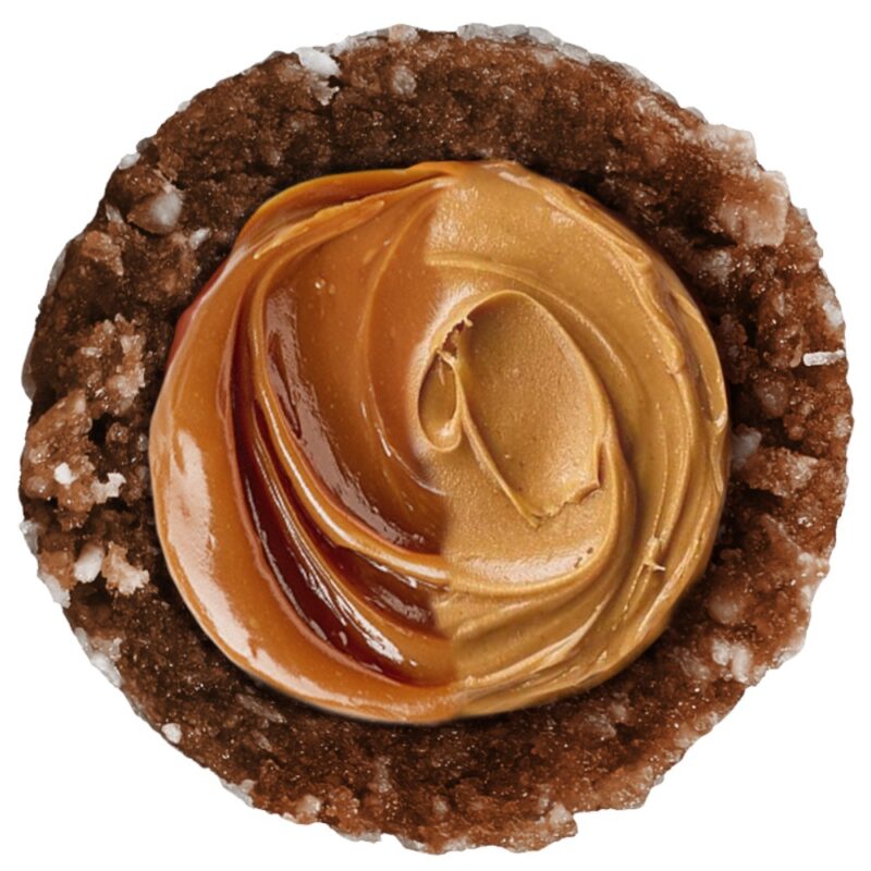 Close-up of a round chocolate ball topped with caramel and peanut butter swirl.